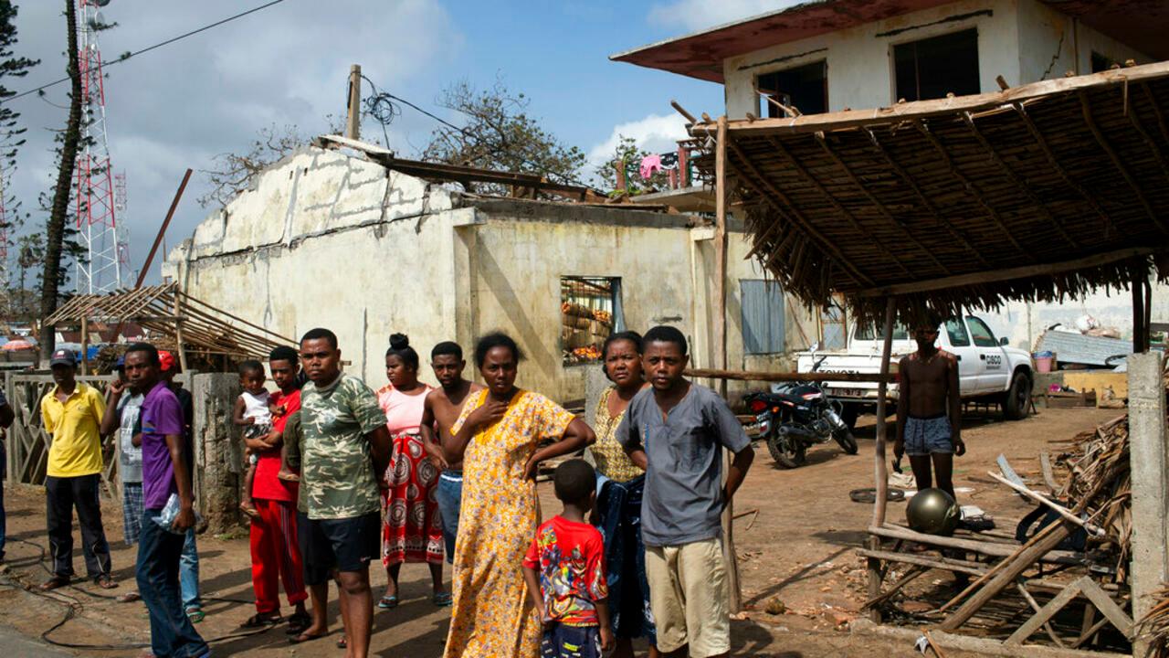 FILE — People outside ruined homes in Mananjary, Madagascar, Feb. 10, 2022. The island of Madagascar off the east coast of Africa is bracing for yet another cyclone having already been hit by three major tropical storms in the last month. Cyclone Emnati is expected to make landfall on the eastern coast of Madagascar late Tuesday Feb. 22, 2022, amid fears it will be a stronger storm than the three that have left nearly 200 people dead this cyclone season. (AP Photo/Viviane Rakotoarivony, File)