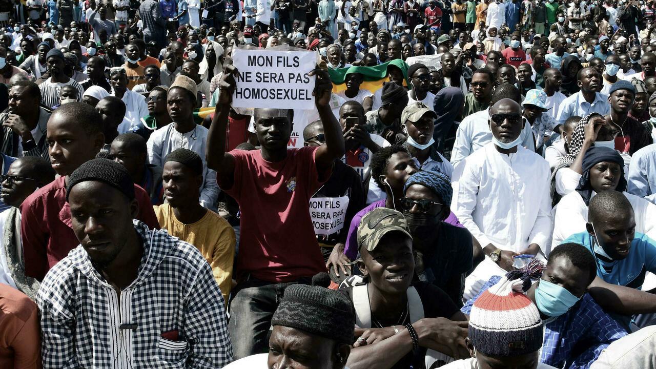 A man holds a sign reading ‘My son will not be an homosexual’ during a protest called by religious associations against homosexuality on May 23, 2021, on the Obelisque square in Dakar. (Photo by Seyllou and SEYLLOU / AFP)
