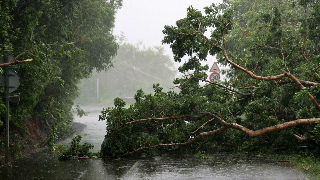 Tree branches block the road with the passage of tropical cyclone Batsirai on the north of the French Indian Ocean island of La Reunion on February 3, 2022, as the island was placed under a cyclonic red alert, forcing the 860,000 inhabitants to barricade themselves. – Reunion had on February 3, 2022 morning a dozen wounded in connection with the passage of cyclone Batsirai, but « the worst has not passed », said the prefect because the eye of the weather phenomenon should pass less than 200 kilometers from the coast in the morning, carrying torrential rains. (Photo by Richard BOUHET / AFP)