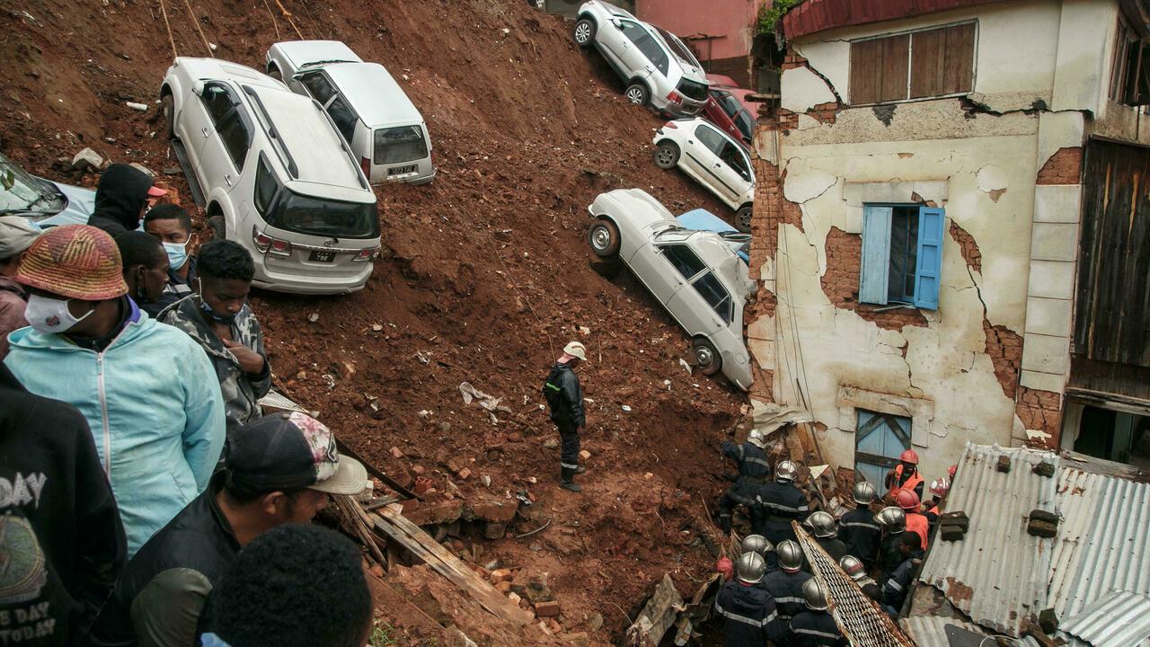 Firefighters search through rubble after a car park housing several private cars collapsed on houses following the heavy rains of the last few days in the Ankadifotsy neighbourhood of Antananarivo on January 24, 2022. – Rescuers recovered five bodies (four children and one adult) from the rubble and are still looking for two missing people who were startled by the landslide in their sleep. Antananarivo and several regions of Madagascar have been hit by strong tropical storms that have caused 34 deaths and more than 62,000 people affected, according to the authorities. (Photo by RIJASOLO / AFP)