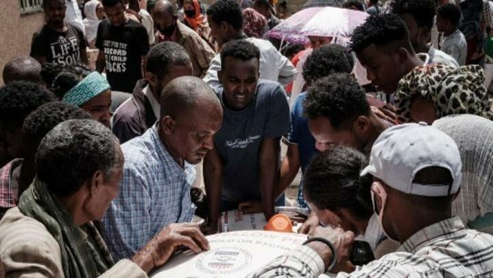 People, who fled the violence in Ethiopia’s Tigray region, gather to receive food during a food distribution organised by the local NGO Relief Society of Tigray (REST) in Mekele, the capital of Tigray region on June 22, 2021. (Photo by Yasuyoshi CHIBA / AFP)