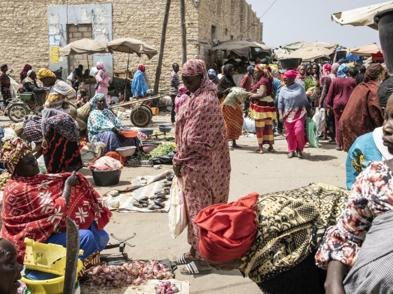 Women buy goods at a market in the historic centre of Rufisque on April 03, 2022, on the first day of Ramadan. (Photo by JOHN WESSELS / AFP)