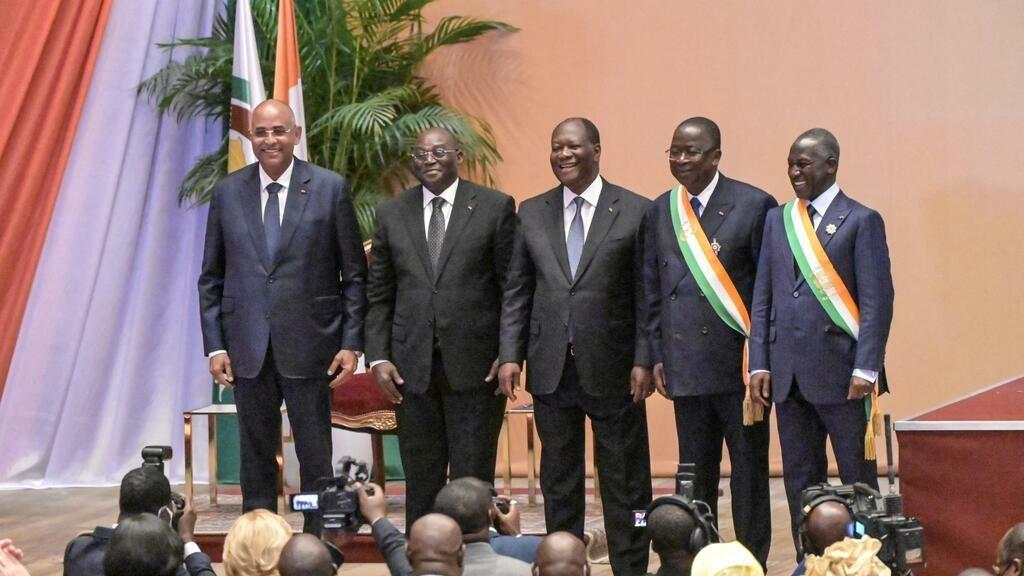 Ivorian President Alassane Ouattara (C), the new Ivorian vice president Tiemoko Meyliet Kone (2nd L), Ivorian Prime Minister Patrick Achi (L), the president of the senate, Jeannot Ahoussou Kouadio (2nd R), and the president of the National Assembly Adama Bictogo (R) pose for a photo in front of senators and parliamentarians at the Felix Houphouet Boigny Foundation for Research in Yamoussoukro on April 19, 2022. (Photo by Sia KAMBOU / AFP)