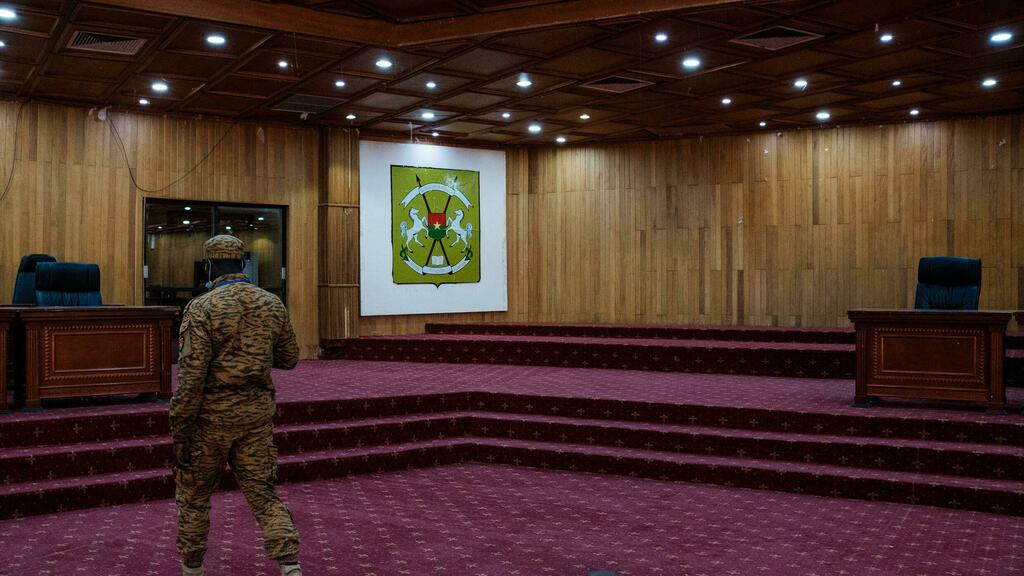 A member of the military preparing the court room before people arrive at the trial of Thomas Sankara in Ouagadougou, Burkina Faso on February 3, 2022 – The trial of 14 men, including a former President Blaise Compaore, over the assassination of the country’s revered revolutionary leader Thomas Sankara 34 years before which was temporarily paused after a military coup until the junta re-established the constitution restarting on February 2, 2022. – The pleadings at the trial of the alleged assassins of the former Burkinabè president Thomas Sankara, killed with 12 of his companions during a coup d’etat in 1987, began on Wednesday, the lawyers for the civil party evoking a moment awaited « by victims for 34 years ». (Photo by GUY PETERSON / AFP)