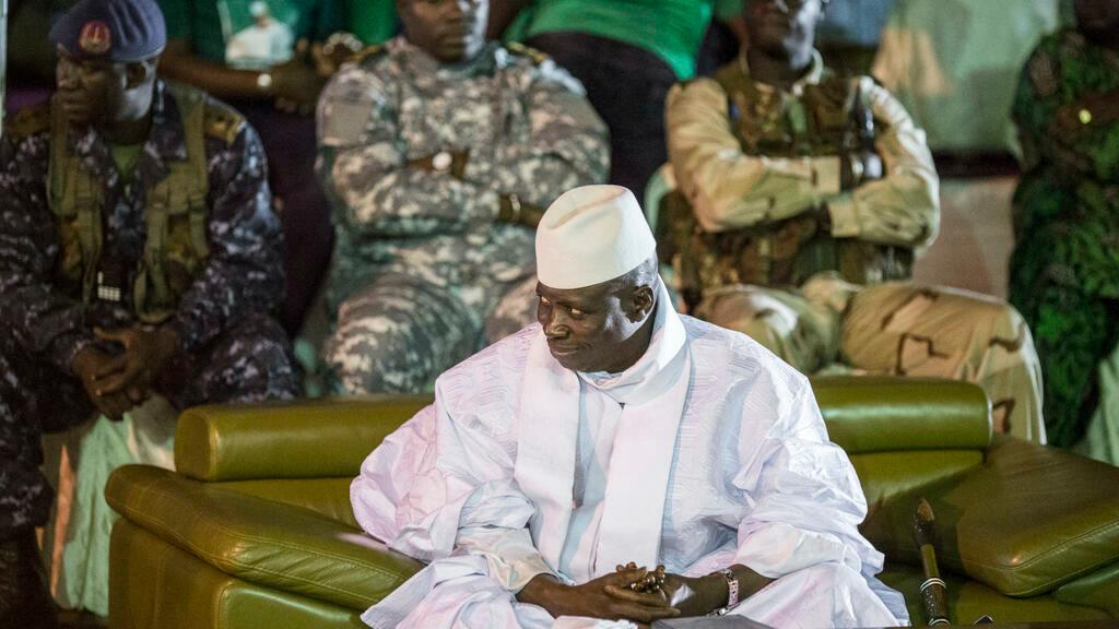 (FILES) In this file photo taken on November 29, 2016 Incumbent Gambian President Yahya Jammeh looks on in Banjul during the closing rally of the electoral campaign of the Alliance for Patriotic Reorientation and Construction (APRC). – The Gambian government said on May 25, 2022 it is willing to prosecute former dictator Yahya Jammeh for a « myriad of crimes » committed by the regime during his more than 20-year rule. (Photo by MARCO LONGARI / AFP)