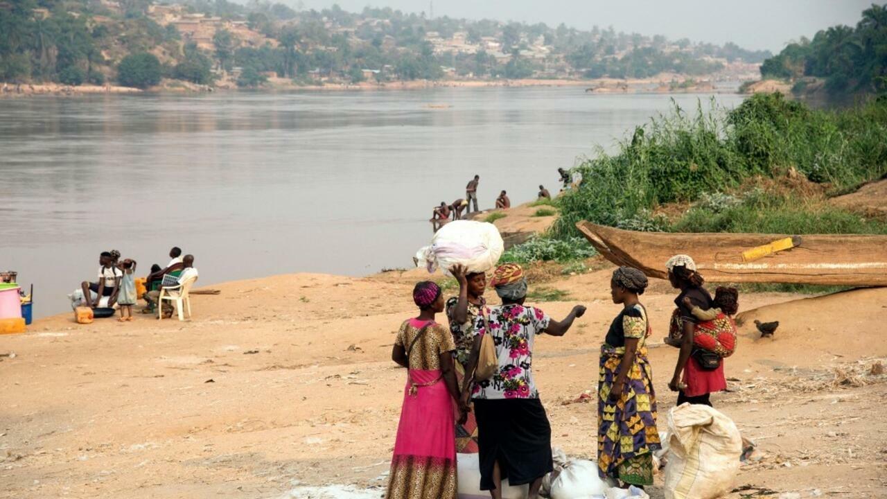 People stand near the Kasai river as the traffic on the river has been slowed down due to insecurity, at the port of Tshikapa, Democratic Republic of Congo on July 28, 2017. (Photo by Junior D. KANNAH / AFP)