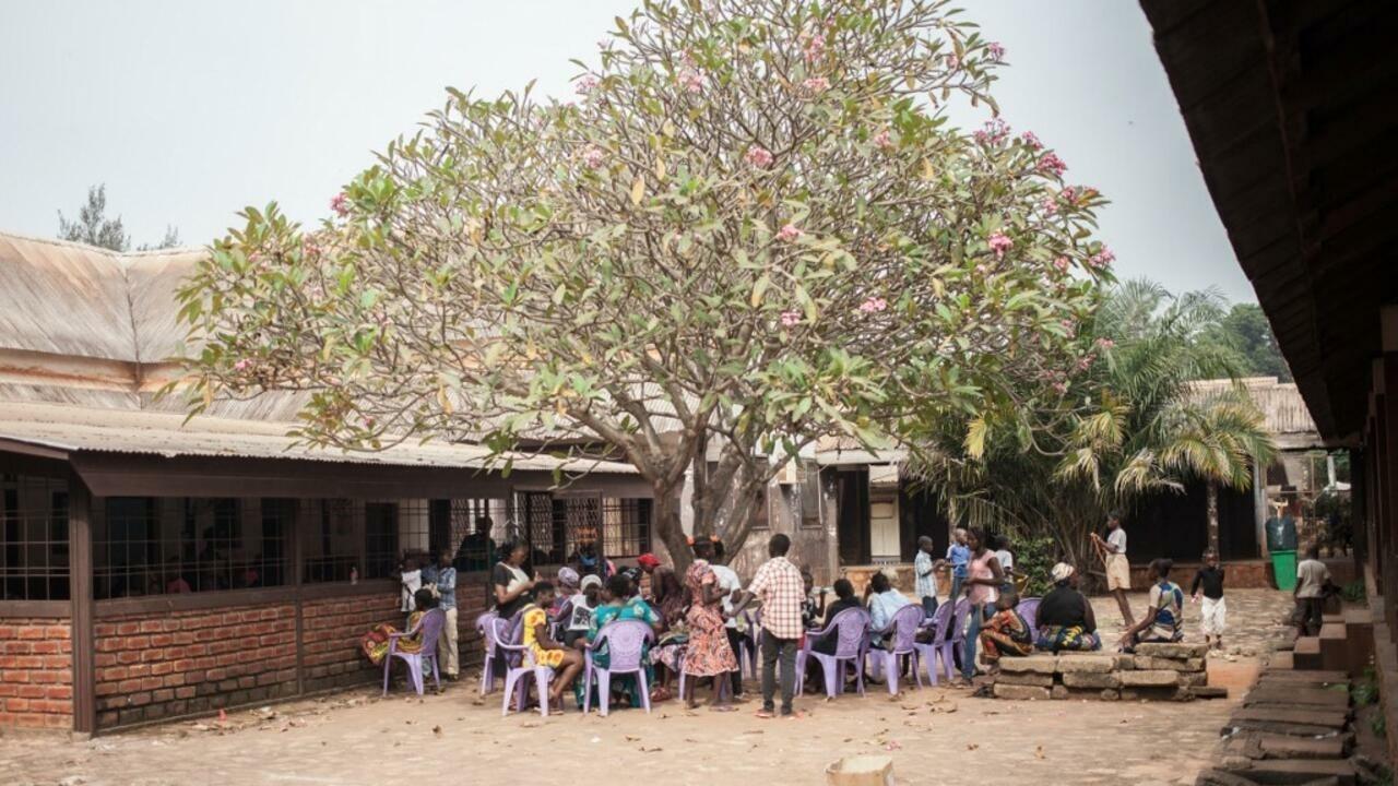 A group of HIV-positive children wait under a tree to receive their antiretroviral drugs at the Bangui paediatric complex on December 4, 2018. (Photo by FLORENT VERGNES / AFP)