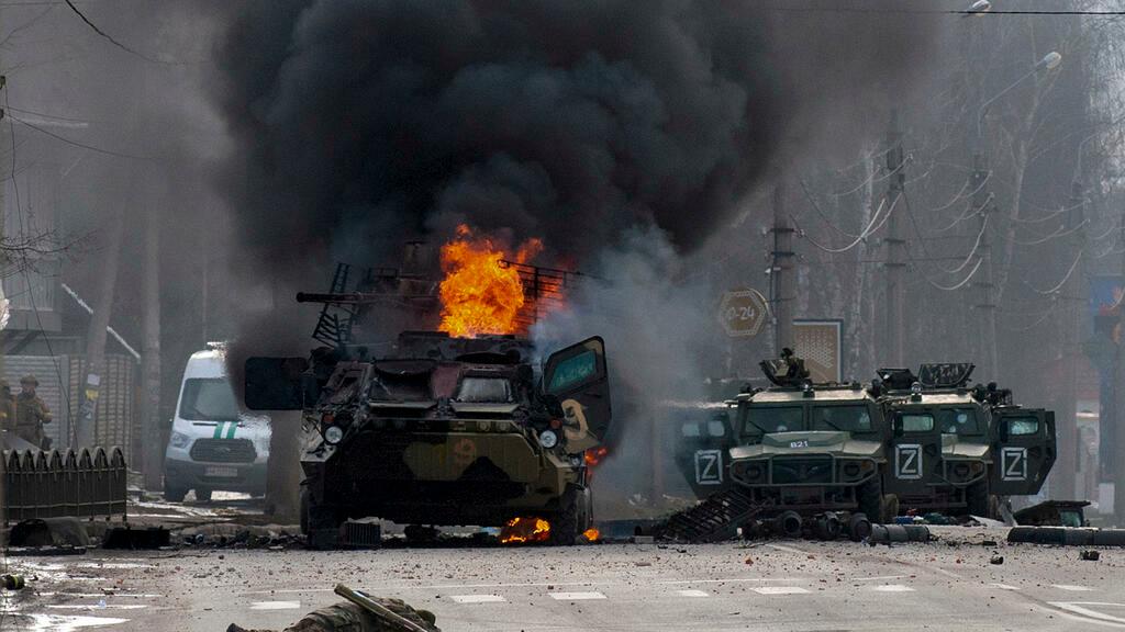 FILE – A Russian armored personnel carrier burns amid damaged and abandoned light utility vehicles after fighting in Kharkiv, Ukraine, Sunday, Feb. 27, 2022. (AP Photo/Marienko Andrew, File)