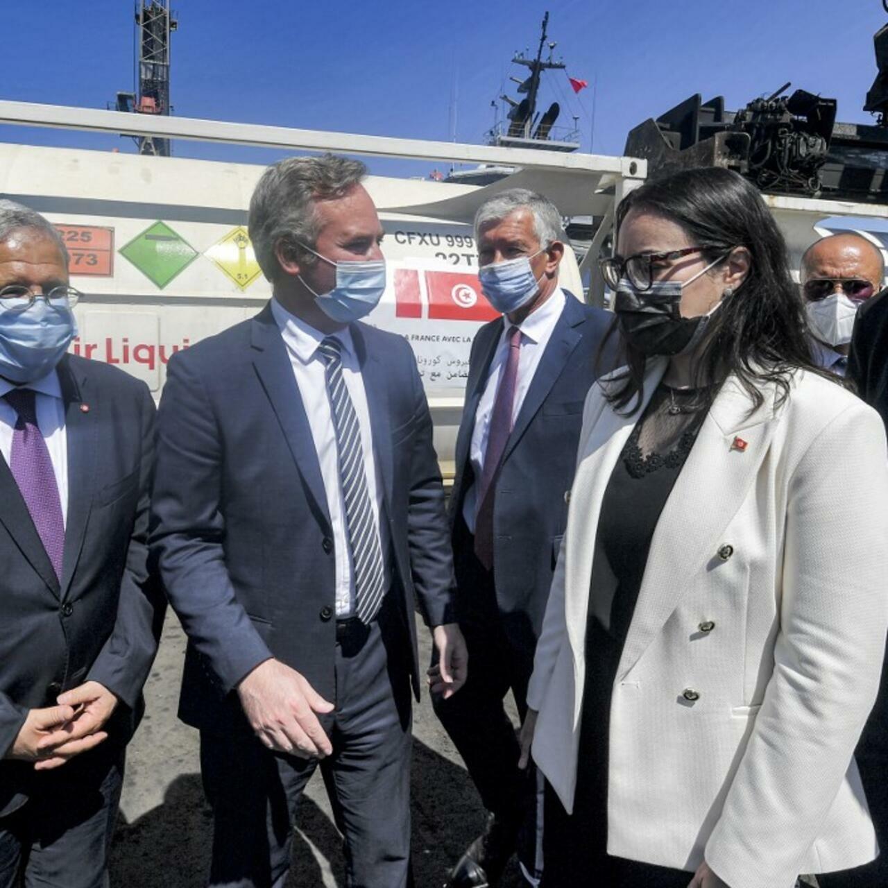 Jean-Baptiste Lemoyne (C), France’s Secretary of State for Tourism, French living abroad, and Francophonie, meets with Tunisia’s Foreign Minister Othman Jerandi (L) and Presidential chief of staff Nadia Akacha (C-R) at the port of Rades on the eastern outskirts of the capital Tunis on July 22, 2021, as they receive a shipment of oxygen supplies given by France to Tunisia as medical aid to combat the COVID-19 coronavirus pandemic. (Photo by FETHI BELAID / AFP)