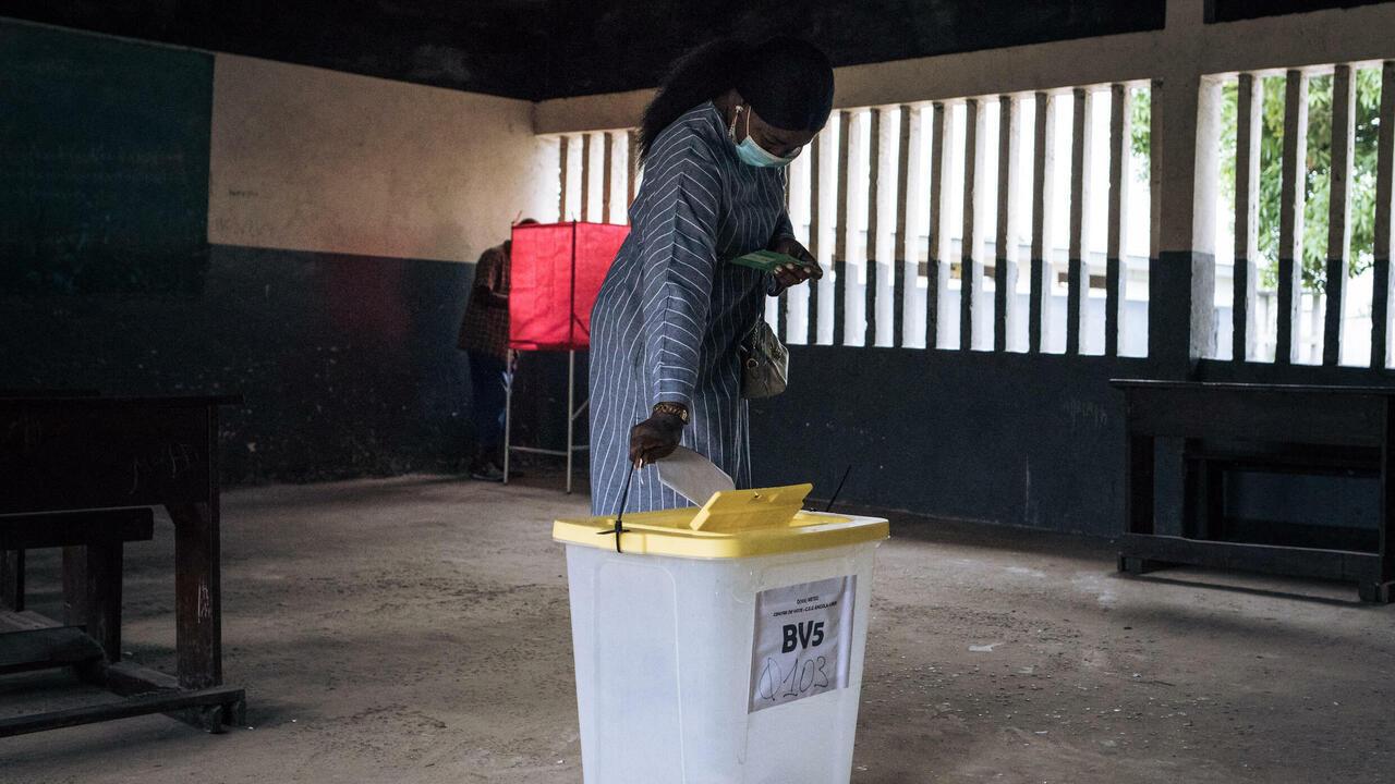 A voter casts her ballot at a polling station at the College D’enseignnement General Commune Makelekele, 1ER Arrondissement, in Brazzaville, Congo, on March 21, 2021. – The Republic of Congo voted on March 21, 2021 in a presidential election boycotted by the main opposition and attacked by critics as tilted towards veteran leader Denis Sassou Nguesso. Access to the internet and social media was cut hours before polls opened at 7:00 am (0600 GMT). (Photo by ALEXIS HUGUET / AFP)