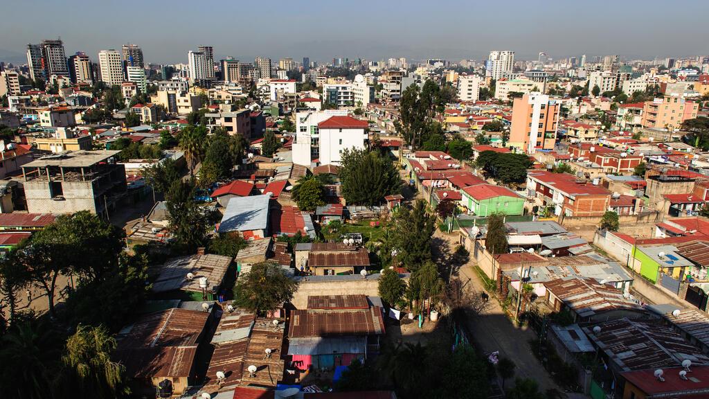 The morning sun shines on the urban sprawl of Addis Ababa below a clear blue sky, Ethiopia